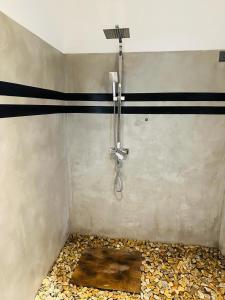 ducha con manguera en una habitación con suelo en Oqura Villa, en Ahangama