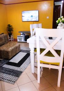a living room with a white table and chairs at S & A APARTMENTS in Thika