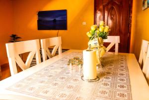a dining room table with a vase of flowers on it at S & A APARTMENTS in Thika