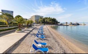a row of blue lounge chairs on a beach at Feel like Home in Podstrana