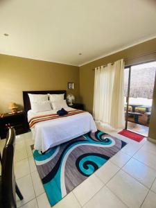 1 dormitorio con cama grande y ventana grande en Good and Proper Guest Lodge, en Vereeniging