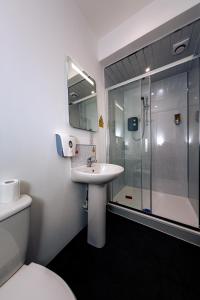 a bathroom with a toilet and a sink and a shower at CHEERZ Apartments in Aberdeen
