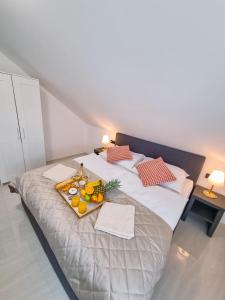 a large bed with a tray of fruit on it at Apartmány u Parku in Lednice