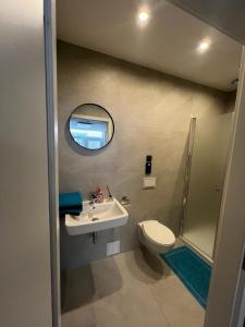 a bathroom with a sink and a toilet and a mirror at Innenstadtwohnung in Sackgasse mit Klima - RMI 2 in Wiener Neustadt