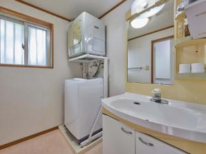 a bathroom with a sink and a white refrigerator at Yukurina Resort Okinawa in Motobu