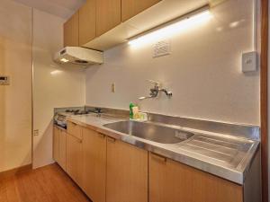 a kitchen with a sink and a stove at Yukurina Resort Okinawa in Motobu