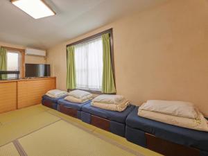 two beds in a room with a window at Yukurina Resort Okinawa in Motobu