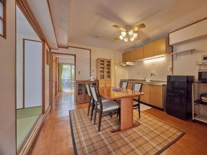 a kitchen with a wooden table and chairs at Yukurina Resort Okinawa in Motobu