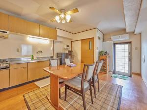 uma cozinha e sala de jantar com uma mesa de madeira e cadeiras em Yukurina Resort Okinawa em Motobu