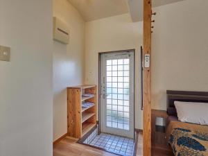 a bedroom with a bed and a glass door at Yukurina Resort Okinawa in Motobu