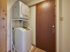 a washing machine with a microwave on top of it at Yukurina Resort Okinawa in Motobu