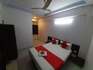 a bedroom with a bed with red and white pillows at hotel royal night in Ahmedabad