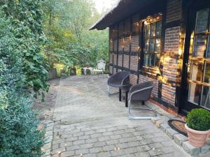 um pátio com duas cadeiras e um edifício em Ferienhaus Oak-Tree-Cottage em Beverstedt