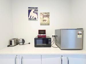 a kitchen counter with a microwave and a refrigerator at Kingfisher Lodge in Lake Tekapo