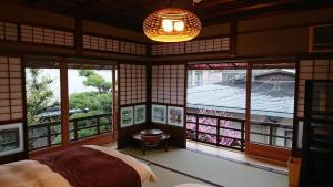 Habitación con cama y habitación con ventanas en 蔵の宿　櫻林亭, en Miwa
