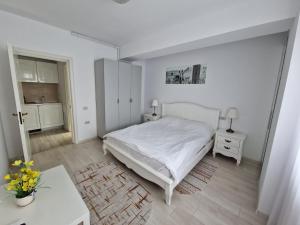 een witte slaapkamer met een bed en een tafel bij Derby Beach Mamaia. in Mamaia