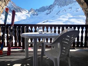 d'une table et d'une chaise sur un balcon avec des montagnes enneigées. dans l'établissement Résidence Pic Du Midi - 2 Pièces pour 4 Personnes 664, à La Mongie