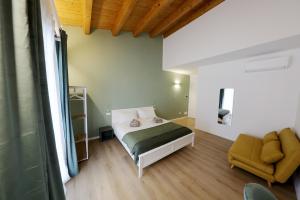 a bedroom with a bed and a chair in a room at Argenteria5 Holiday Rooms in Palermo