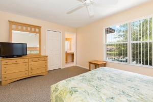 a bedroom with a bed and a flat screen tv at Kosies Lake Escape in Orlando