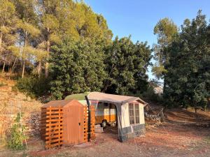 una caravana y un cobertizo sentados en un campo en Casa del Paso, en Bolulla