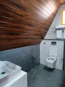 La salle de bains est pourvue de toilettes et d'un lavabo. dans l'établissement Suvarna Eco Village, à Madikeri