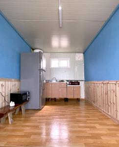uma grande cozinha com paredes azuis e pisos de madeira em 바다와정원 Sea and Garden em Boryeong