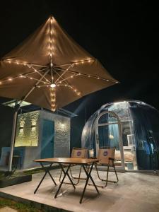 stół i krzesła z dużym parasolem w obiekcie The Starry Dome w mieście Cameron Highlands