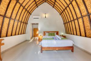 a bedroom with a bed and a large arched ceiling at Puri Garden Penida in Nusa Penida