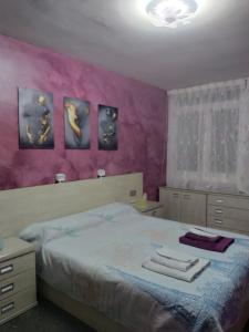 濱海普雷米亞的住宿－Suite en 1a línea de Playa con piscina a 20 minutos de Barcelona，一间卧室配有一张紫色墙壁的床