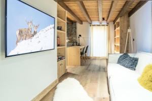 un soggiorno con una grande TV a parete di Chalet L'etable - CHALET | SAINT-MARTIN-DE-BELLEVILLE MAE-4304 a Saint-Martin-de-Belleville