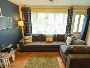 a living room with a leather couch and a window at 12 The Dell in Norwich