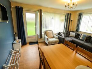 a living room with a couch and a table at 8 Royal Chalet Park in Norwich