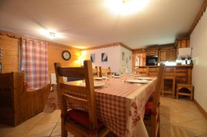 une salle à manger avec une table et une cuisine dans l'établissement Résidence Hameau Des Marmottes - 4 Pièces pour 6 Personnes 514, aux Menuires