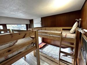 a room with three bunk beds in a house at Résidence Oisans - 2 Pièces pour 6 Personnes 824 in Les Menuires