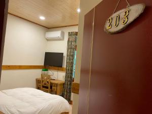 a room with a bed and a tv in a room at Taoyuan Villa B&B in Puli