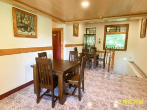 a dining room with a wooden table and chairs at Taoyuan Villa B&B in Puli
