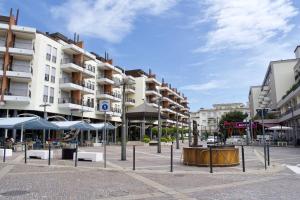 a city square with buildings and tables and umbrellas at Marconi Deluxe - Attico a Due Passi dal Mare in Lido di Jesolo