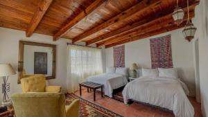- une chambre avec deux lits et une chaise dans l'établissement Tierra y Amor San Miguel de Allende, à San Miguel de Allende