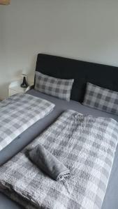 Una cama con sábanas a cuadros y almohadas. en Ferienwohnung Villa Portugal, en Leinsweiler