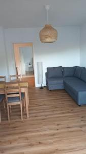 sala de estar con sofá azul y mesa en Ferienwohnung Villa Portugal, en Leinsweiler