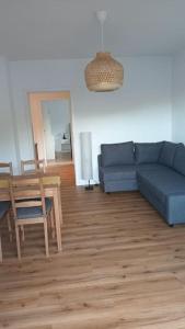 un soggiorno con un divano blu e un tavolo di Ferienwohnung Villa Portugal a Leinsweiler