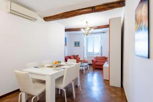 een witte eetkamer met een witte tafel en stoelen bij Malapaga Genoa Historic Center - Happy Rentals in Genua
