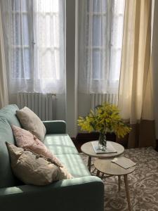 Villa Julia في Capvern: غرفة معيشة مع أريكة زرقاء وطاولة