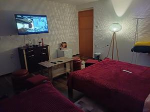 a hotel room with a bed and a tv on the wall at Himber Rooms in Sarajevo
