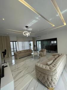 - un grand salon avec un canapé et une table dans l'établissement Résidence ADJIBADE, à Cotonou