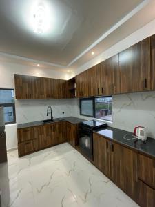 une cuisine avec des placards en bois et des comptoirs noirs dans l'établissement Résidence ADJIBADE, à Cotonou