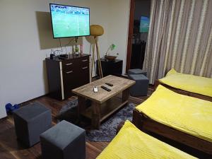 a living room with two beds and a tv at Himber Rooms in Sarajevo