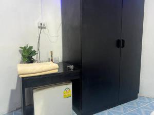 armadio nero accanto a un frigorifero in camera di Sunset Serenity Cove (11) a Ko Phangan