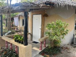 una piccola casa con una porta bianca e alcune piante di Sunset Serenity Cove (11) a Ko Phangan