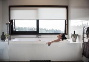 Una mujer acostada en una bañera en una cocina con ventana en Borrodell Vineyard en Orange